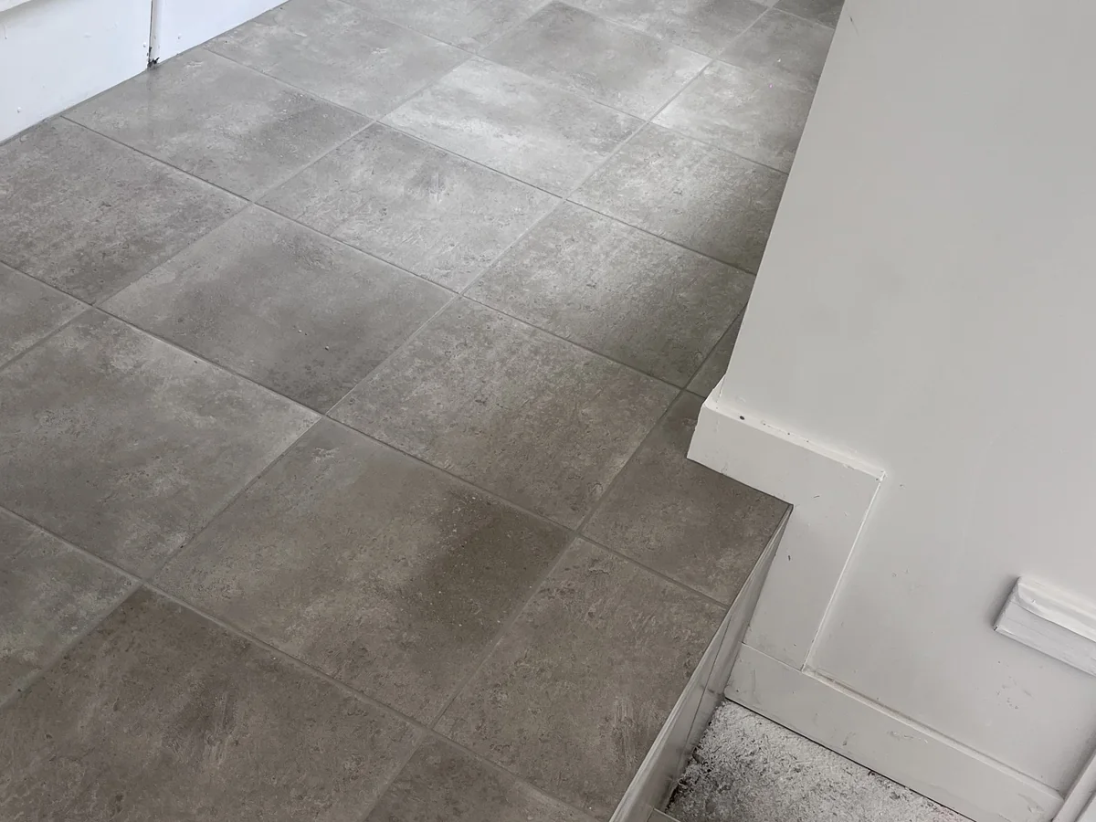 Hallway and step floor tiling finished with neat edges and transitions.