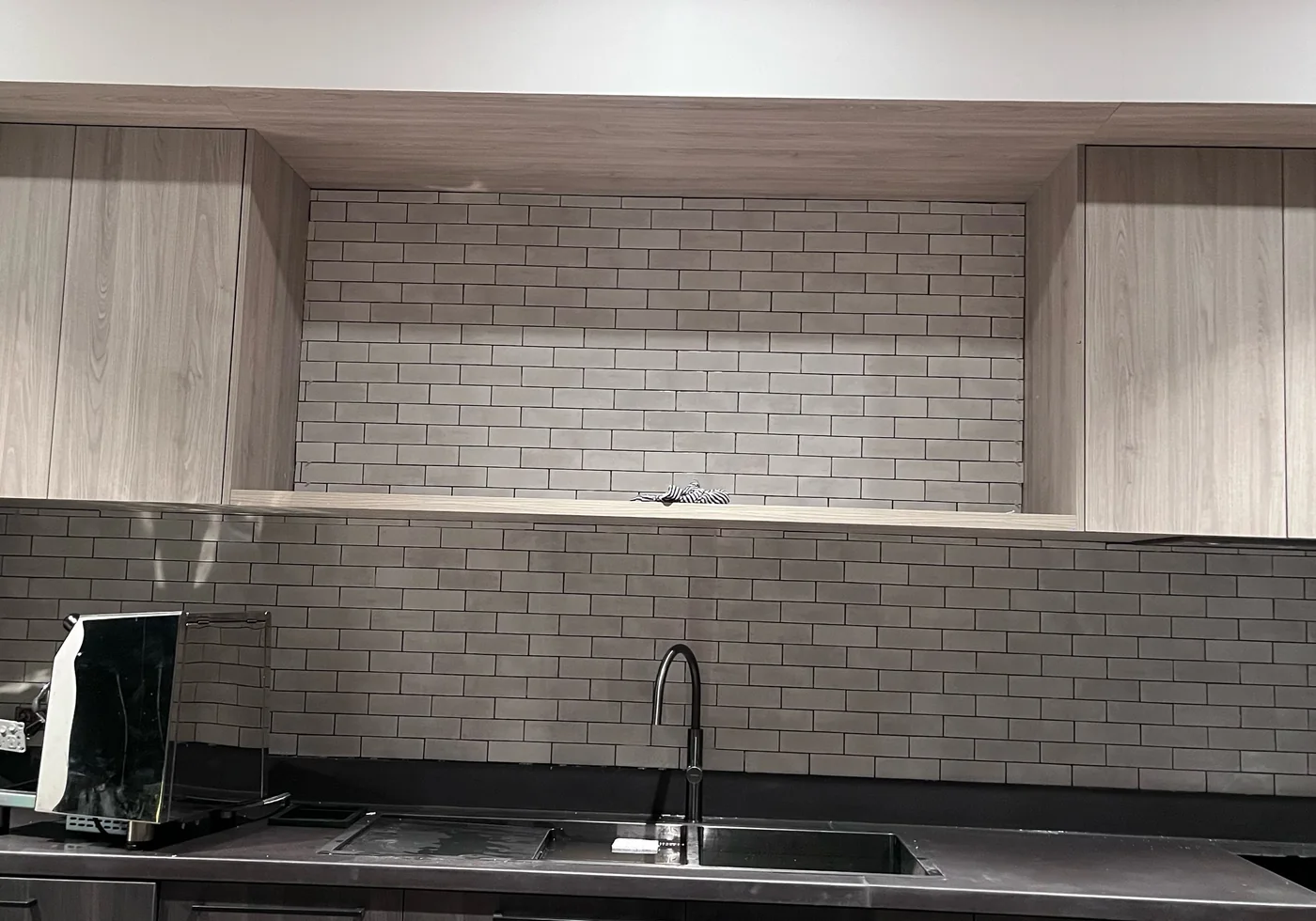 Kitchen splashback tiling with small-format brick tiles.