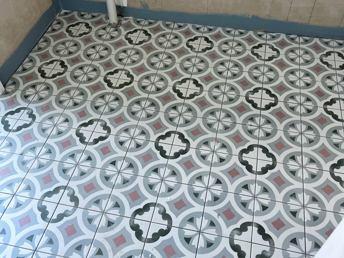 Pattern floor tiles installed in a compact residential room.