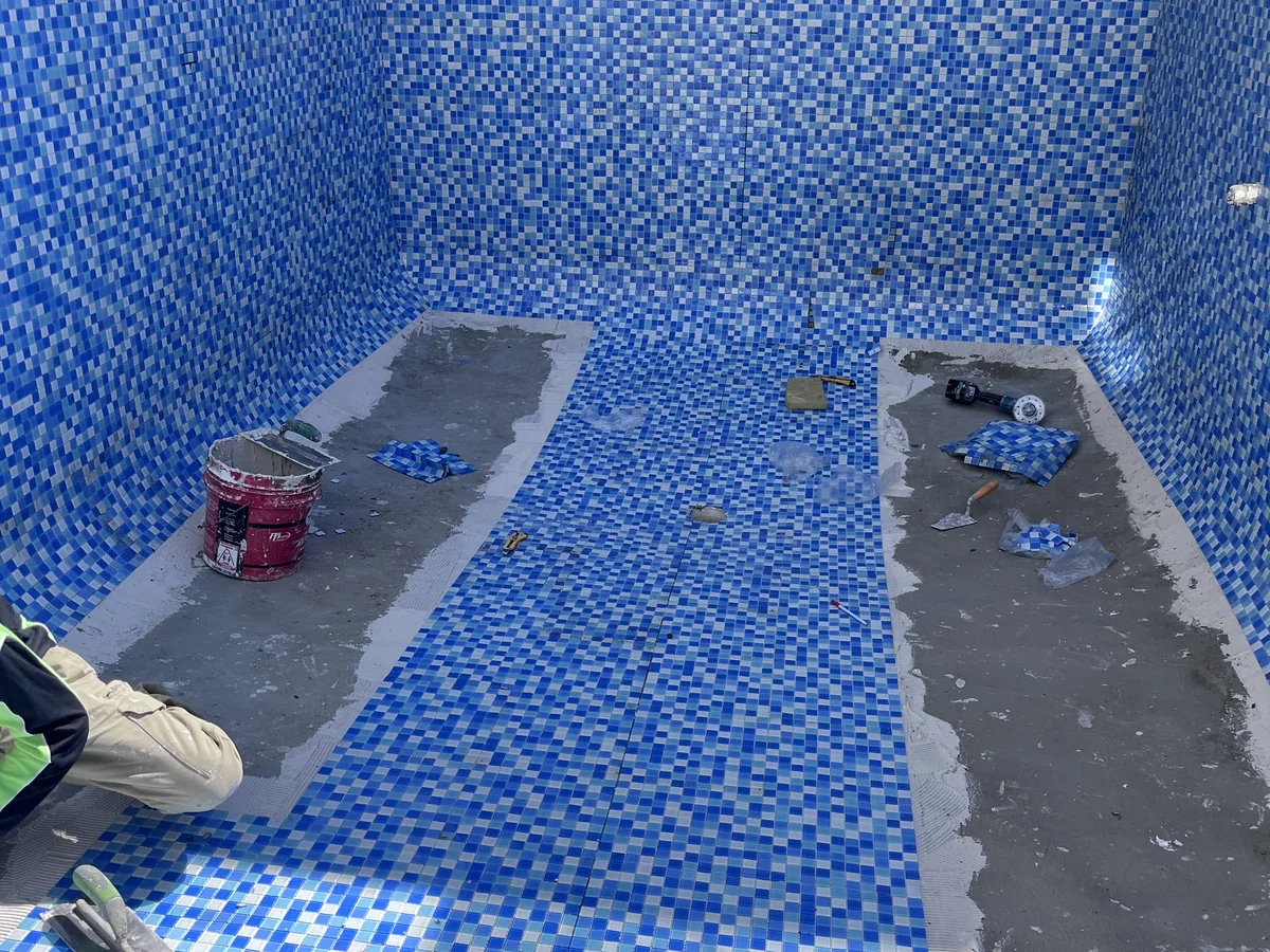 Swimming pool tiling with blue mosaic finishes for a residential pool.